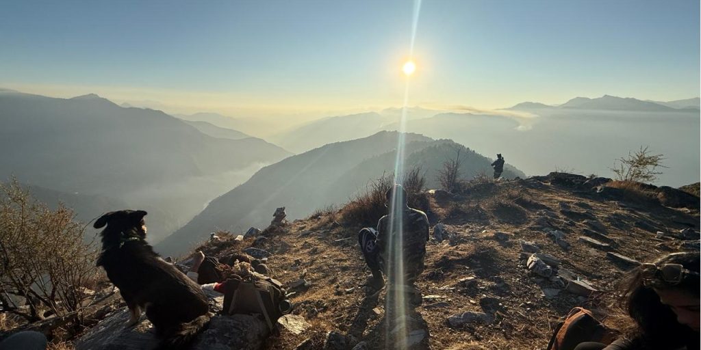 "Vast snow-covered meadow of Dayara Bugyal with distant Himalayan peaks and blue winter sky"